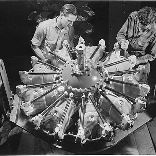 512px-Two_workers_installing_single_row_intake_pipes_on_a_new_Pratt_and_Whitney_airplane_engine_in_a_big_Eastern_plant._-_NARA_-_195474.jpg
